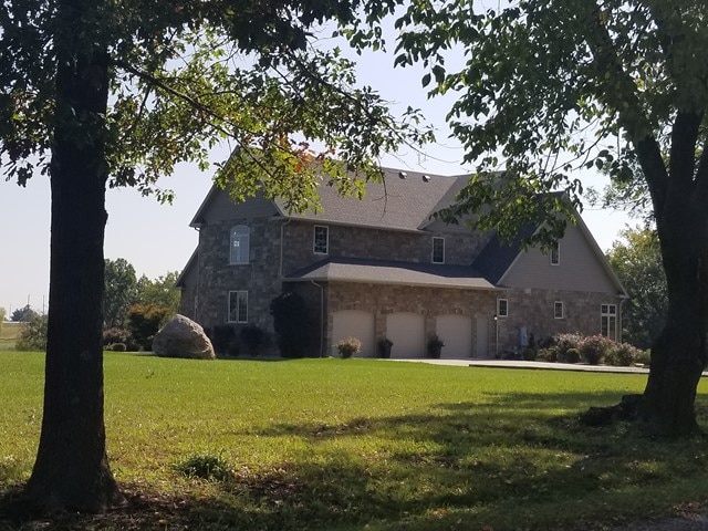 back of house featuring a garage and a lawn