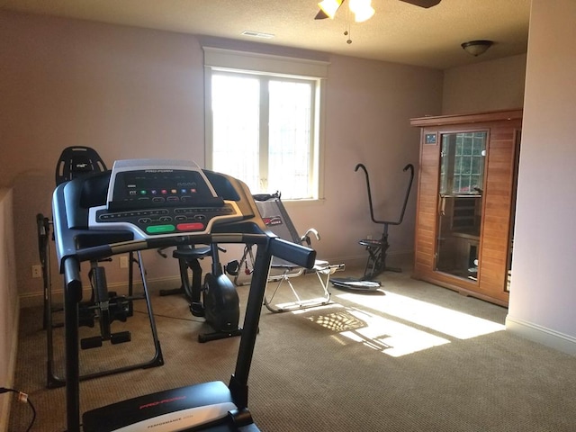 workout room with ceiling fan and carpet