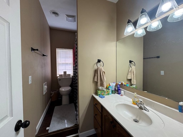 53895 E 3rd St, Milan, MO 63556 - bathroom with visible vents, toilet, vanity, and baseboards
