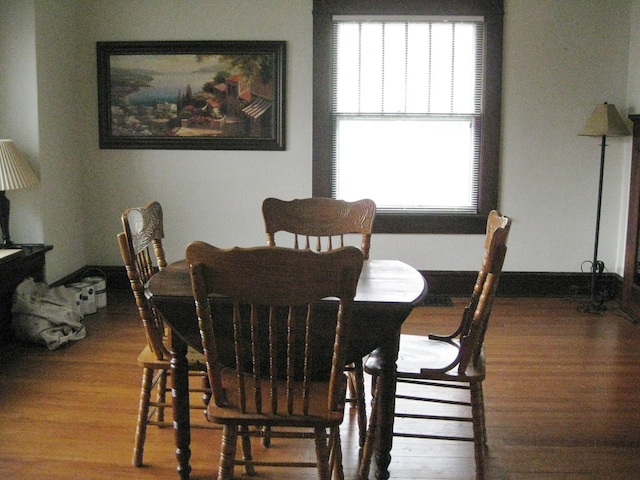 dining area with a wealth of natural light and hardwood / wood-style flooring