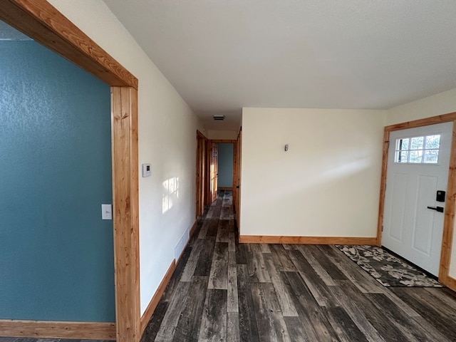 foyer entrance featuring visible vents, baseboards, and dark wood finished floors