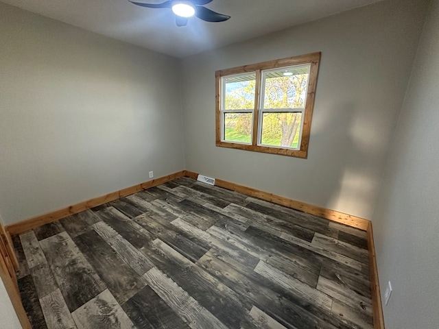unfurnished room with visible vents, a ceiling fan, baseboards, and dark wood finished floors