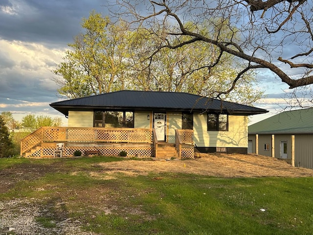 view of front of house featuring a front yard and metal roof