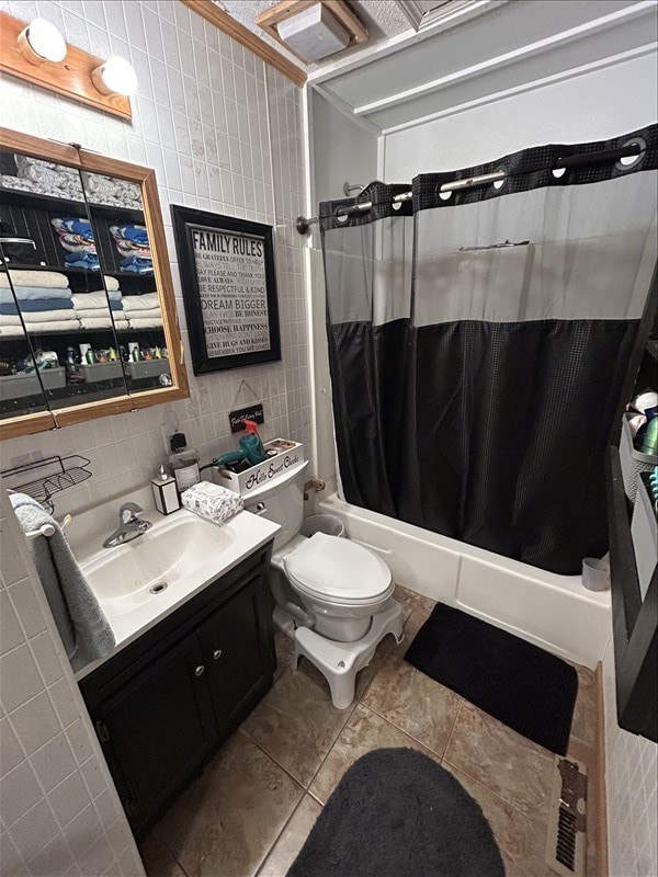 116 Adams St, Centralia, MO 65240 - full bath with tile walls, vanity, shower / bath combo with shower curtain, toilet, and tile patterned floors