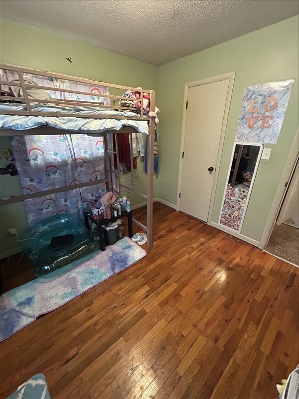116 Adams St, Centralia, MO 65240 - bedroom with wood finished floors and a textured ceiling