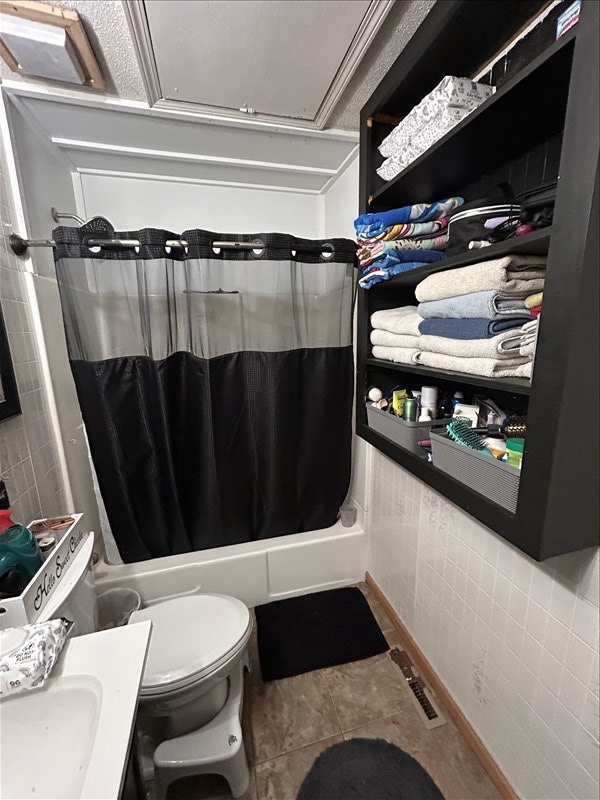 116 Adams St, Centralia, MO 65240 - full bath featuring tile walls, toilet, shower / bath combination with curtain, tile patterned floors, and vanity