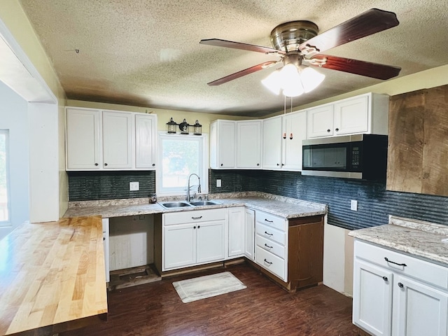 kitchen featuring white cabinetry, dark hardwood / wood-style flooring, decorative backsplash, sink, and ceiling fan