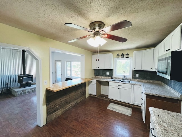 kitchen with tasteful backsplash, dark hardwood / wood-style floors, sink, and white cabinetry