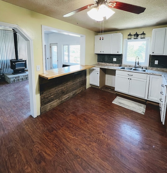 kitchen with dark hardwood / wood-style flooring, backsplash, white cabinets, and sink