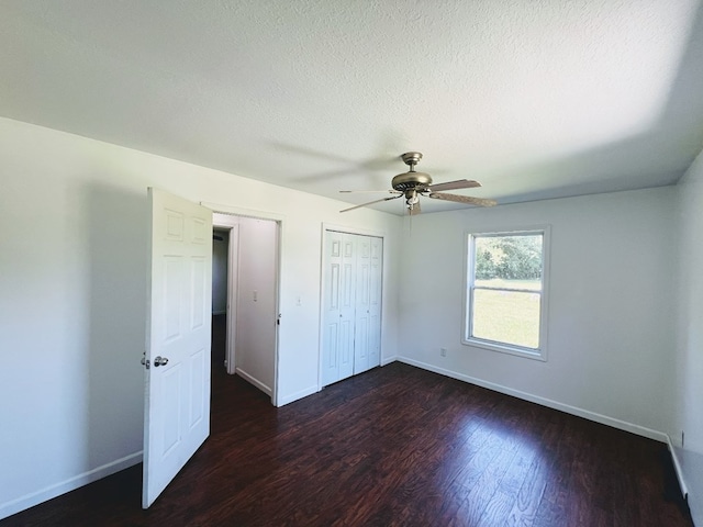 unfurnished bedroom featuring ceiling fan and dark hardwood / wood-style flooring