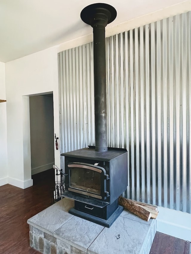 details with a wood stove and wood-type flooring