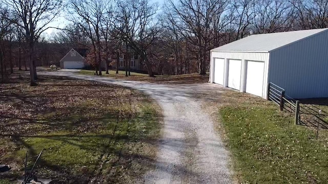 view of yard with a garage and an outbuilding