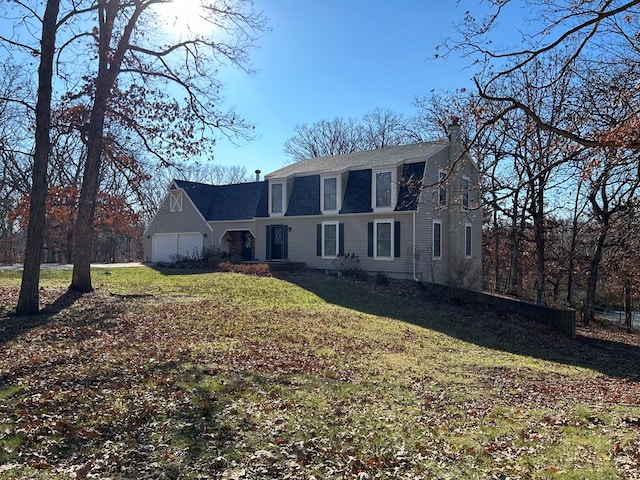 view of front of house featuring a garage and a front lawn