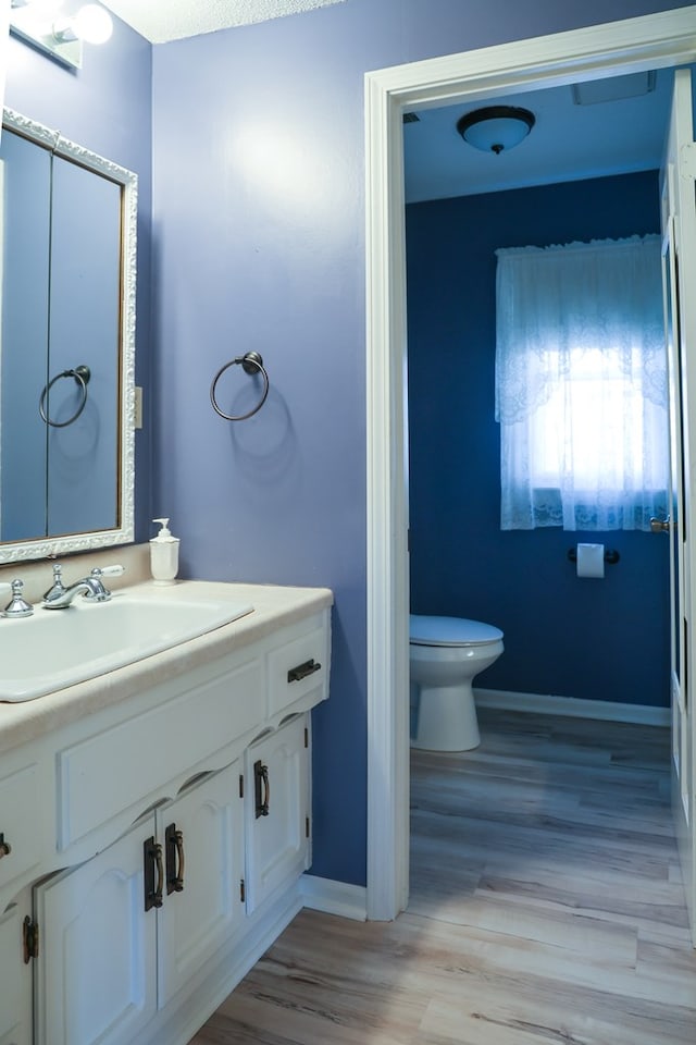 bathroom featuring vanity, toilet, and wood-type flooring