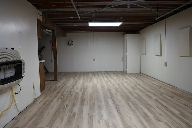 basement with heating unit and light hardwood / wood-style floors