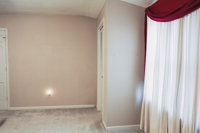 unfurnished bedroom with light colored carpet and a textured ceiling