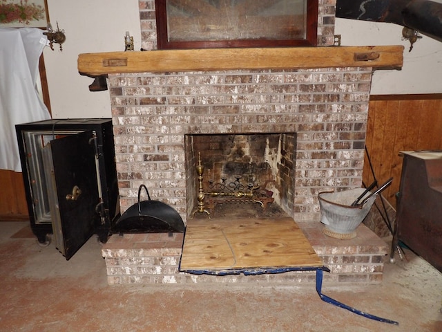 room details featuring a brick fireplace and wooden walls