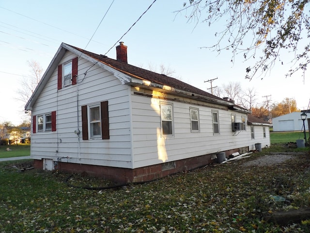 view of side of property featuring a lawn and cooling unit