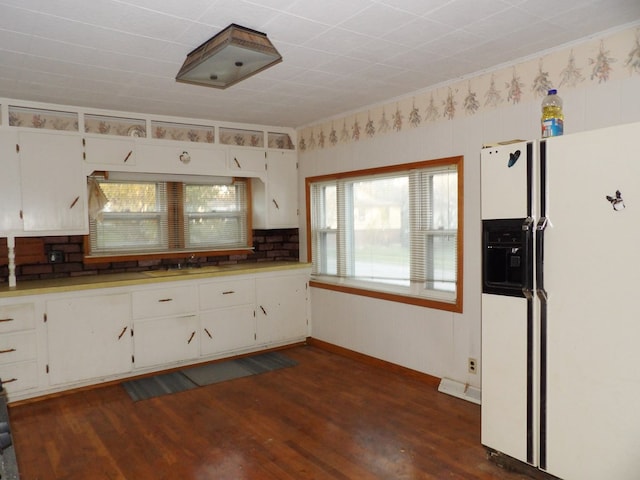 kitchen with dark hardwood / wood-style flooring, white fridge with ice dispenser, and white cabinets