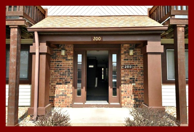 206 Woodwinds Ct, Kirksville, MO 63501 - doorway to property with brick siding and a shingled roof