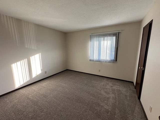 206 Woodwinds Ct, Kirksville, MO 63501 - empty room featuring dark colored carpet, a textured ceiling, and baseboards