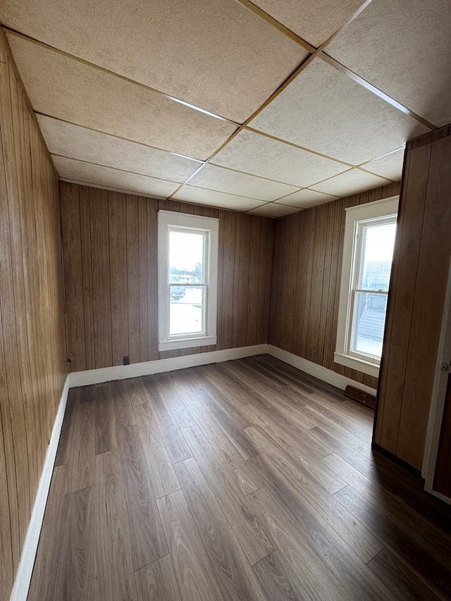 spare room featuring hardwood / wood-style flooring, plenty of natural light, and wood walls