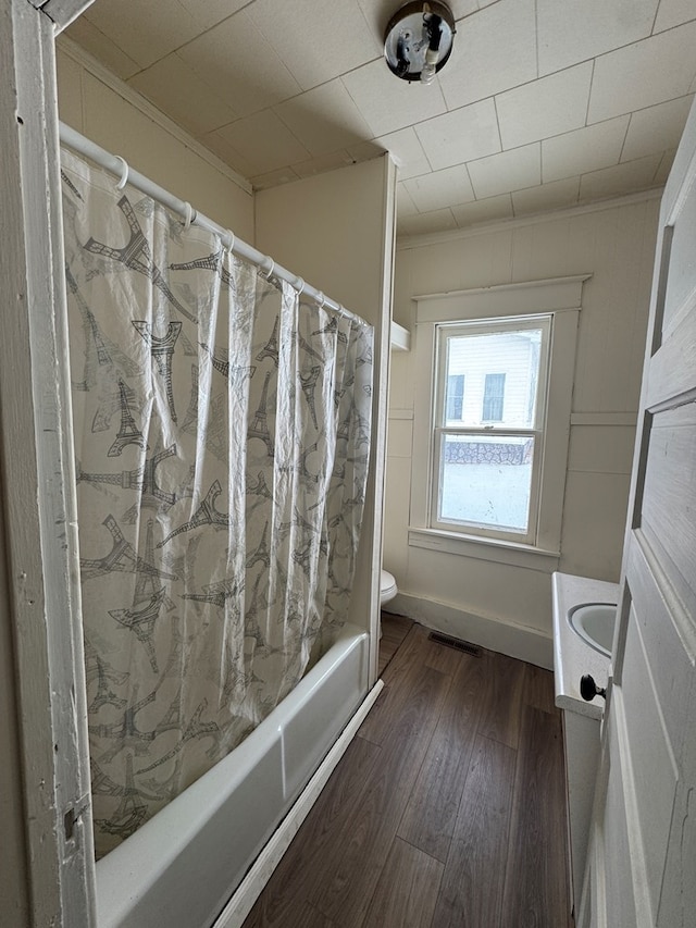 full bathroom with toilet, hardwood / wood-style flooring, shower / bath combo, ornamental molding, and vanity