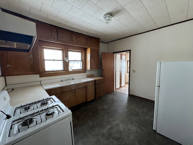 kitchen featuring sink, white appliances, and ornamental molding