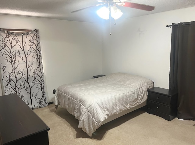 bedroom with ceiling fan, light colored carpet, and a textured ceiling