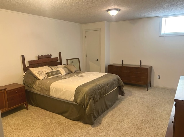 bedroom with light carpet and a textured ceiling