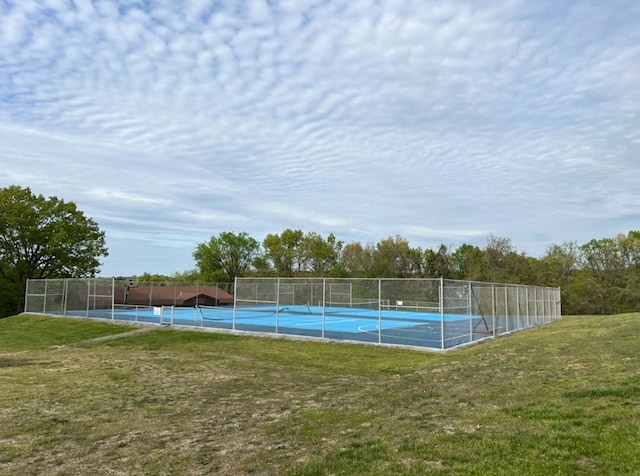 view of sport court with a lawn