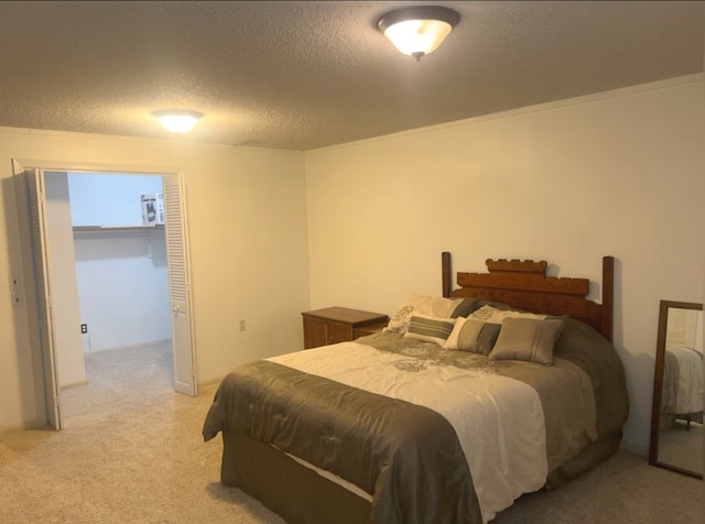 carpeted bedroom featuring a textured ceiling, a closet, and crown molding