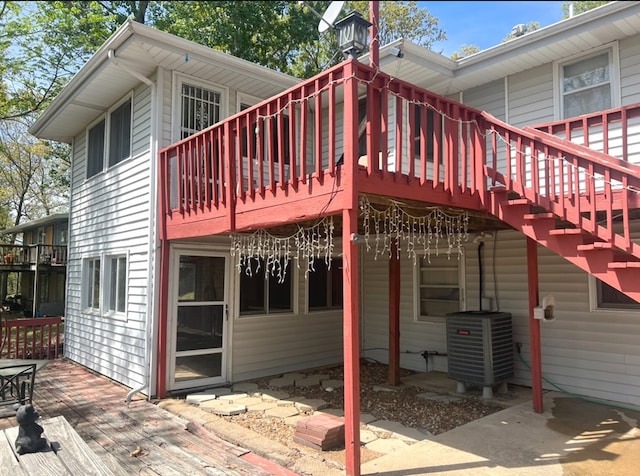 rear view of house with a wooden deck and central AC