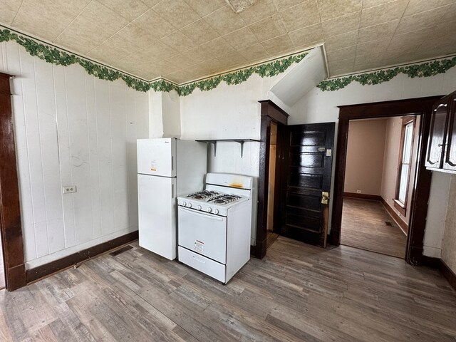 kitchen featuring hardwood / wood-style floors, sink, white appliances, and dark brown cabinetry