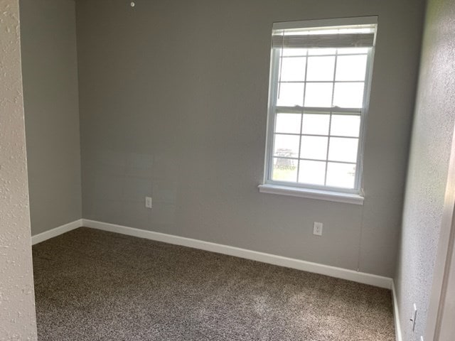 601/603 W Laharpe St, Kirksville, MO 63501 - carpeted empty room with baseboards and a textured wall