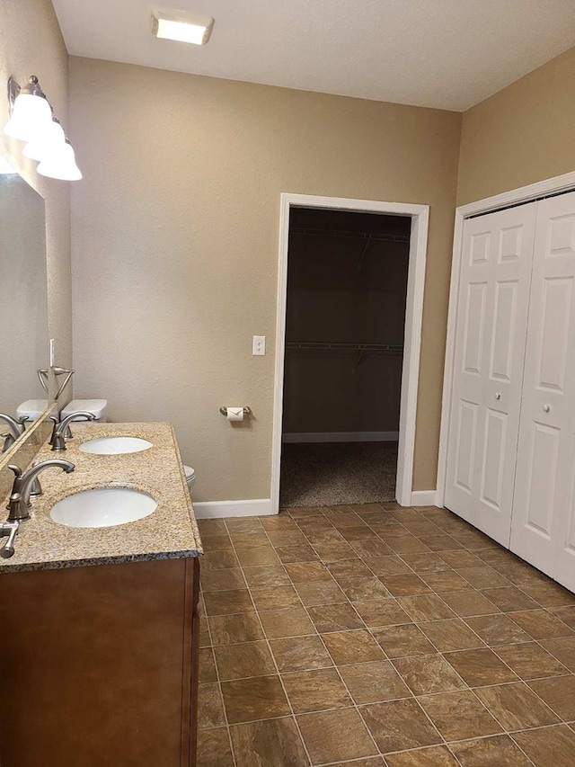 601/603 W Laharpe St, Kirksville, MO 63501 - bathroom with double vanity, baseboards, a sink, and toilet