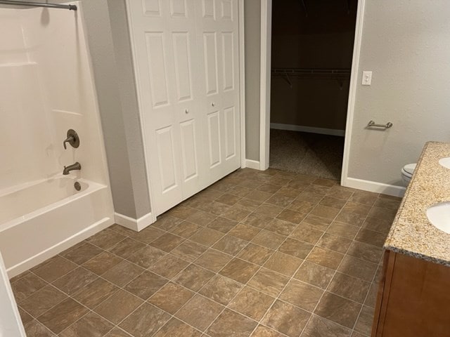 601/603 W Laharpe St, Kirksville, MO 63501 - bathroom featuring toilet, washtub / shower combination, baseboards, and vanity