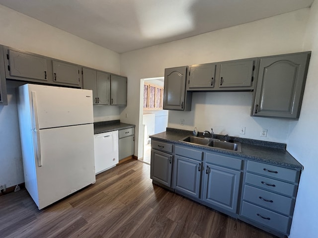 kitchen featuring sink, white appliances, dark wood-type flooring, and gray cabinets