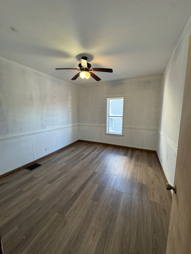 empty room with ceiling fan and dark wood-type flooring