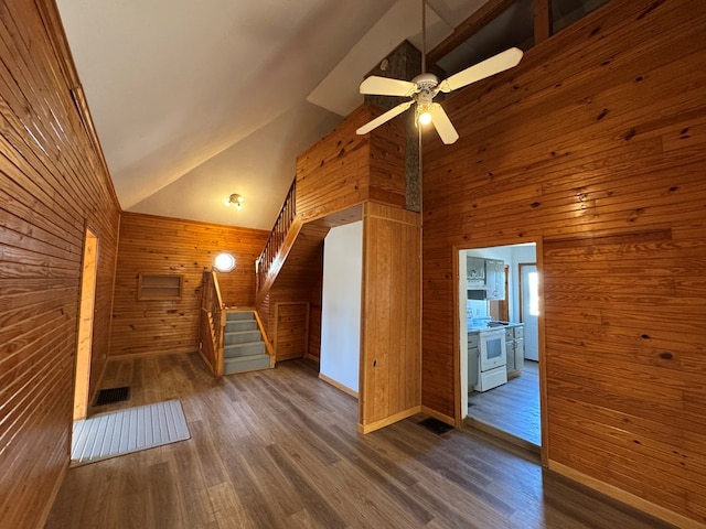 bonus room with ceiling fan, dark hardwood / wood-style floors, high vaulted ceiling, and wood walls