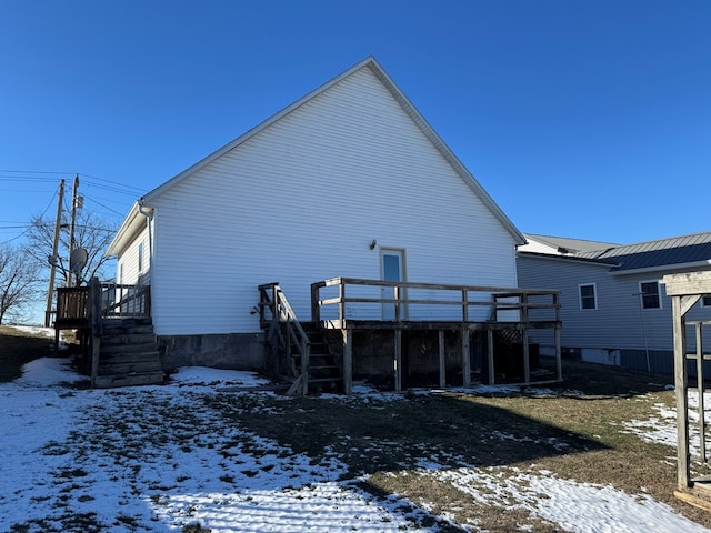 snow covered property with a deck