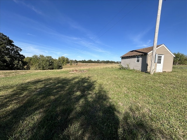 view of yard featuring a rural view and an outdoor structure