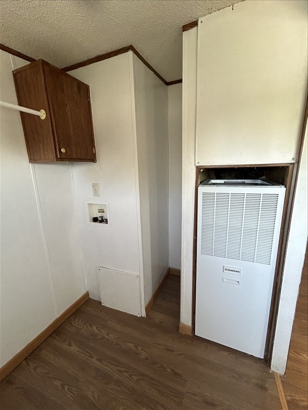 laundry area featuring hookup for a washing machine, a textured ceiling, dark hardwood / wood-style floors, and crown molding