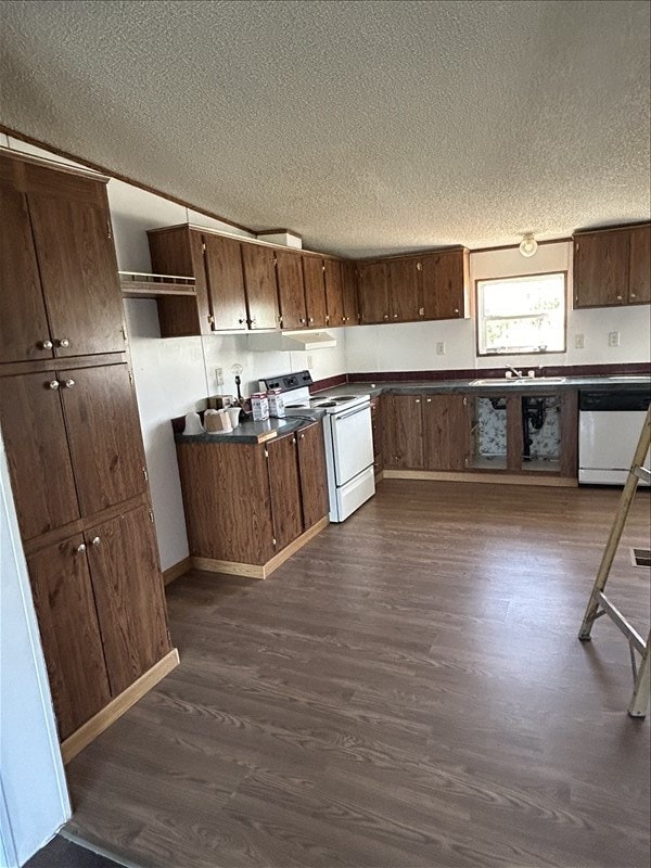 kitchen featuring a textured ceiling, dark hardwood / wood-style floors, white appliances, and sink