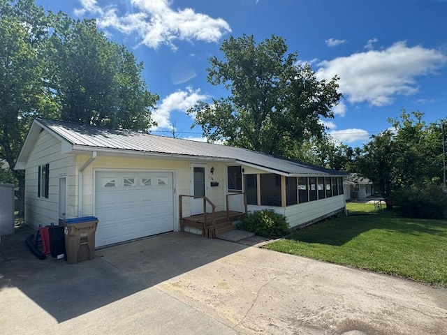236 N Maple St, Milan, MO 63556 - ranch-style home with a front yard, an attached garage, driveway, a sunroom, and metal roof