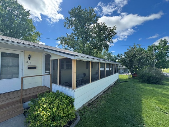 236 N Maple St, Milan, MO 63556 - view of side of property with a sunroom, a lawn, and metal roof