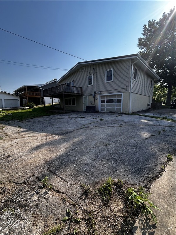 804 Maple Ln, Macon, MO 63552 - back of house featuring asphalt driveway, an attached garage, and a deck