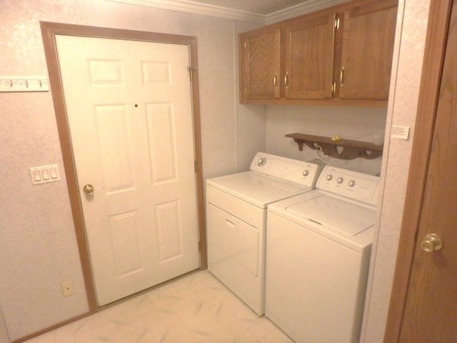 laundry room with marble finish floor, washing machine and clothes dryer, cabinet space, and crown molding