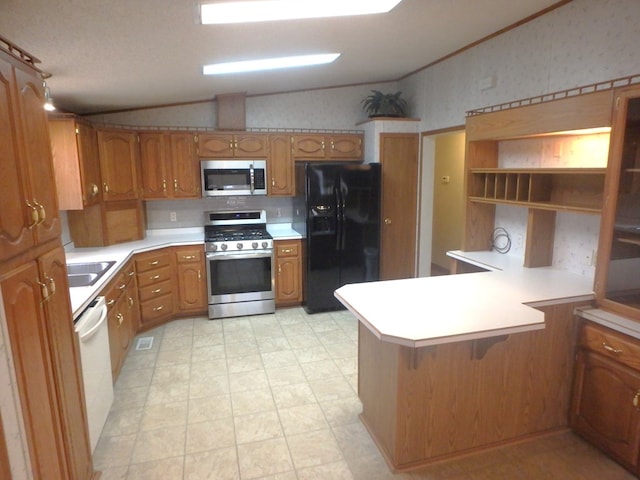 kitchen featuring lofted ceiling, stainless steel appliances, a peninsula, and light countertops