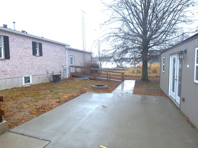 view of yard featuring central AC unit, an outdoor fire pit, a patio area, and fence